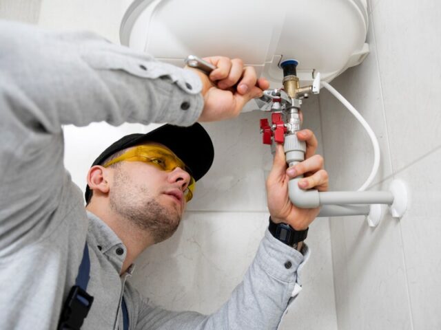 https://happyhvacsolutions.com/wp-content/uploads/2024/09/worker-repairing-water-heater-640x480.jpg